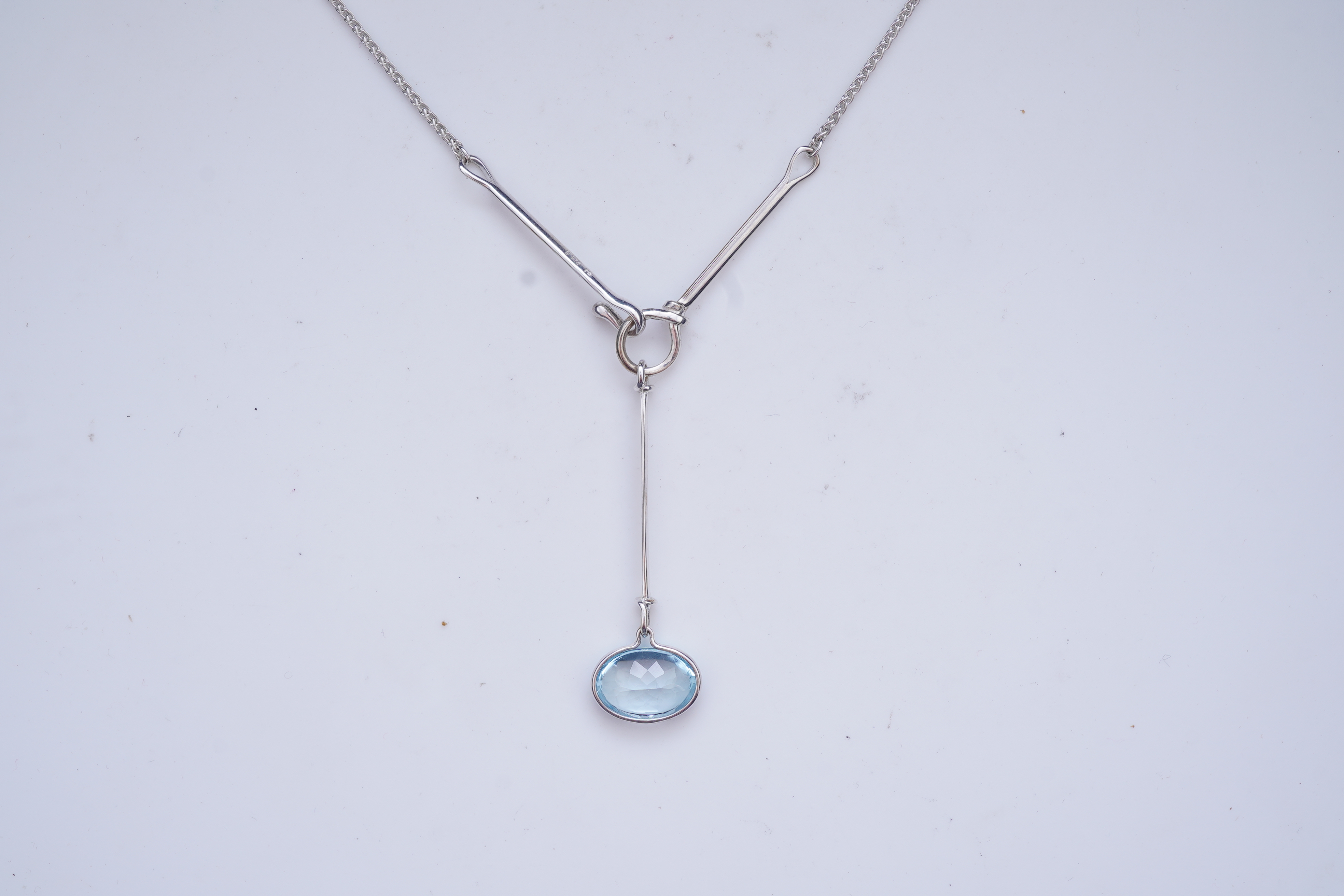 Georg Jensen, a blue topaz necklace, centring on a hook clasp suspending an oval blue topaz pendant, pendant length 5.5cm, necklace length 43cm, stamped GJ for Georg Jensen, 925S and European convention assay marks for s